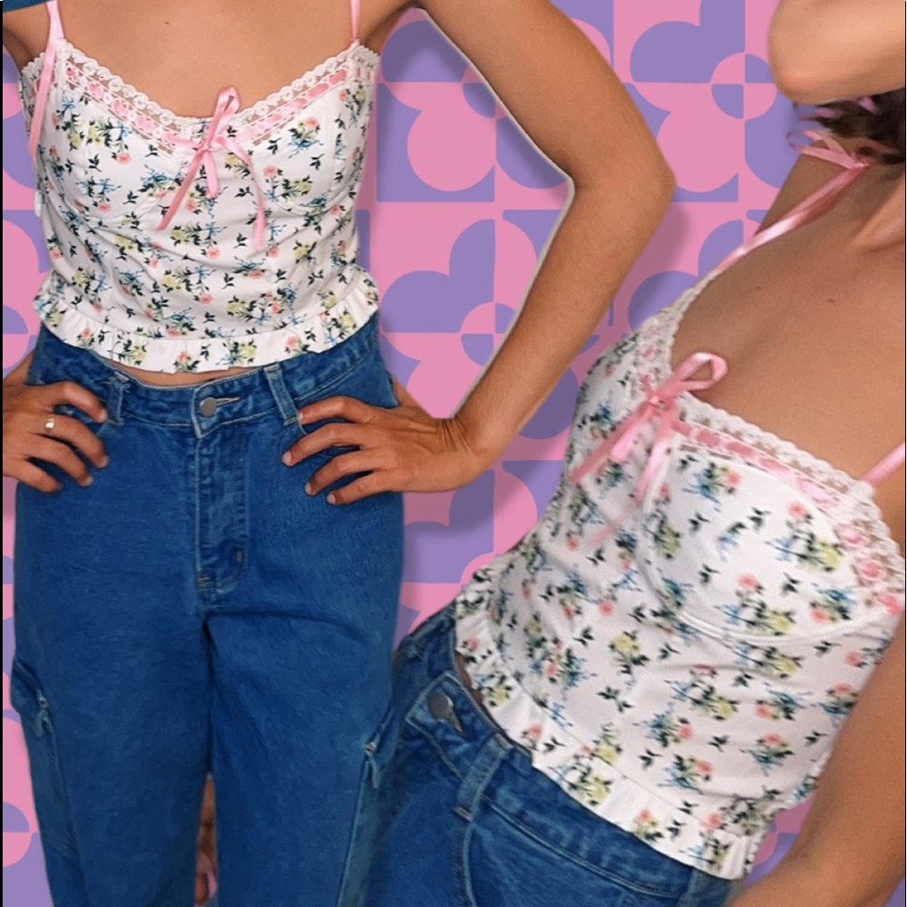 White crop top with small flowers, lace detailing, and pink ribbon ties.
